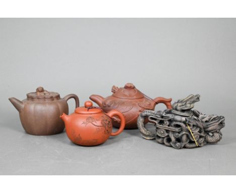 Four Chinese Yixing teapots; a lobed teapot and cover with guardian lion finial 10 cm; a 'dragon' design example with moulded