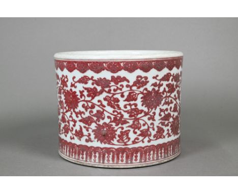 A Chinese red and white cylindrical jardiniere, painted in underglaze copper red with a wide band of lotus scroll between ruy