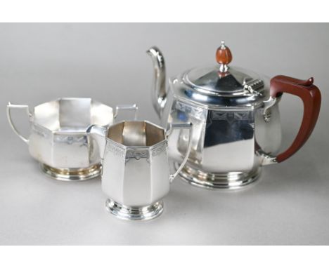 A heavy quality Art Deco silver tea set of octagonal form, with engraved decoration and composite mounts, on raised and mould