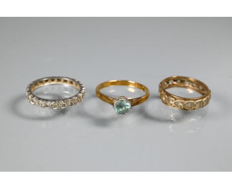 An 18ct yellow gold ring set with single aquamarine, size O, a diamond set white metal eternity ring and a white stone set ye