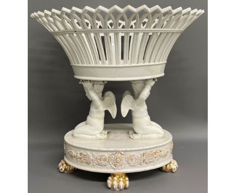 Ceramic table centre piece in the form of a basket supported by two putti (damage to top of basket) Ht35cm