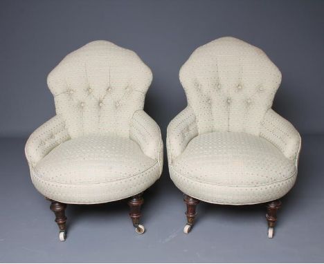 A PAIR OF VICTORIAN WALNUT FRAMED NURSING CHAIRS button upholstered in a pale green weave, arched back, downswept arms, bowed