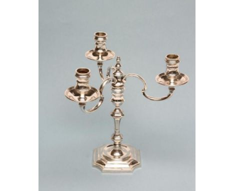 A GEORGE I STYLE SILVER THREE BRANCH CANDELABRUM, maker Carringtons, Birmingham 1977, the reel sockets in dished drip pans is