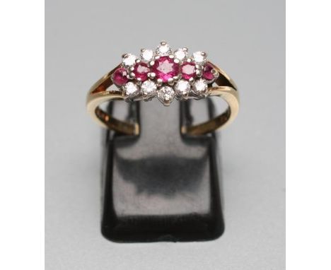 A VICTORIAN STYLE RUBY AND DIAMOND RING, the five graduating rubies line set to an open border of ten small diamonds to open 