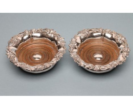 A PAIR OF OLD SHEFFIELD PLATE BOTTLE COASTERS of lobed circular form, the everted rims stamped and filled with fruiting vine,