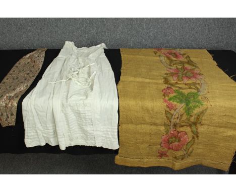 A collection of textiles, including hand embroidered panel with floral and foliate design along with a silk cummerbund with I