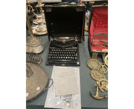 A VINTAGE REMINGTON COMPACT PORTABLE TYPEWRITER COMPLETE WITH CASE AND INSTRUCTIONS 