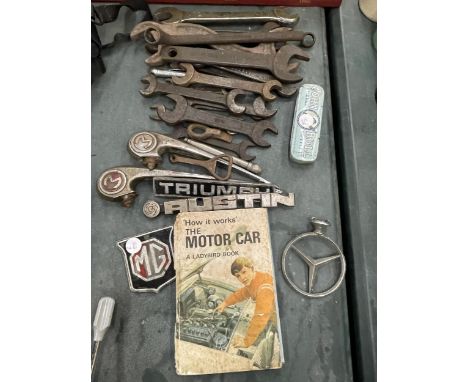 A QUANTITY OF CAR RELATED ITEMS TO INCLUDE A MERCEDES BONNET BADGE, TRIUMPH, AUSTIN AND M G CAR BADGES, VINTAGE SPANNERS, ETC