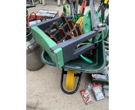 AN ASSORTMENT OF GARDEN TOOLS TO INCLUDE A WHEEL BARROW, A HOSE REEL AND A BATTERY HEDGE TRIMMER ETC 