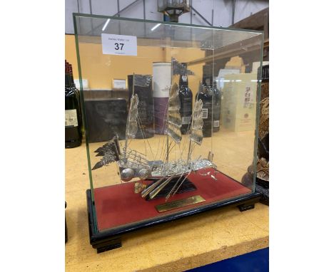 A PRESENTATION SILVER EFFECT WHITE METAL MODEL OF A BOAT IN  A GLASS DISPLAY CASE 