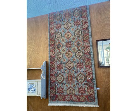 A LARGE NARROW BLUE AND RED PATTERNED HALL RUNNER 