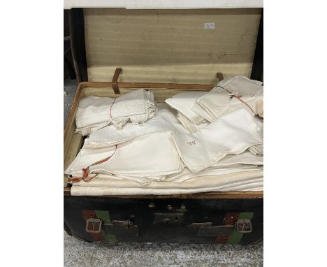 A LARGE VINTAGE TRAVELLING TRUNK CONTAINING A SUBSTANTIAL QUANTITY OF VINTAGE LINEN 