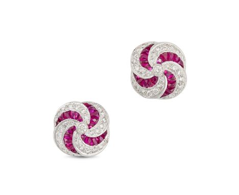 A PAIR OF RUBY AND DIAMOND EARRINGS in 18ct white gold, each stud in a scrolling design, set with French cut rubies and round