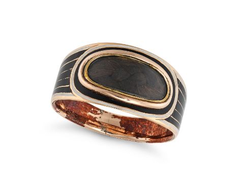 AN ANTIQUE ENAMEL MOURNING RING in yellow gold, set with an oval glass locket panel with hairwork, decorated with black and w