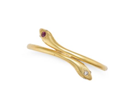 A RUBY AND DIAMOND SNAKE BANGLE in yellow gold, the hinged bangle designed as two coiled snakes, the heads set with a round b