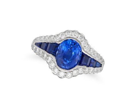 A SAPPHIRE AND DIAMOND RING in platinum, set with an oval cut sapphire of approximately 2.76 carats flanked by calibre cut sa