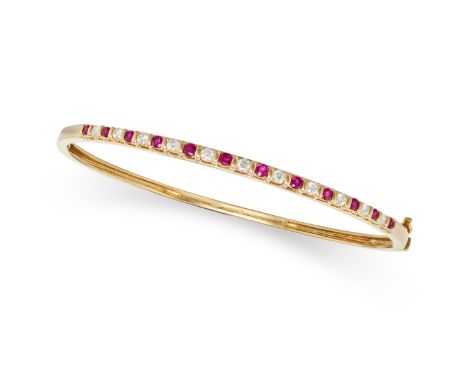 A RUBY AND DIAMOND BANGLE in 18ct yellow gold, the hinged bangle set with a row of alternating round cut rubies and round bri