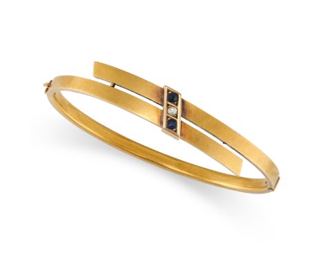 A VINTAGE SAPPHIRE AND DIAMOND BANGLE in 15ct yellow gold, the hinged body in crossover design, set with two round cut sapphi