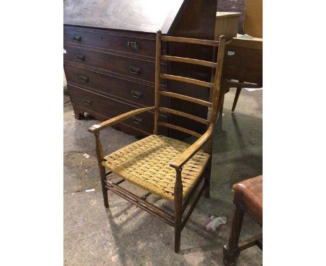 A late 19thc/early 20thc elm low chair with ladder back above a rush seat, on turned supports united by stretchers (88cm x 50