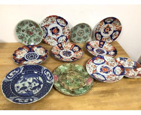 A collection of seven Imari dishes, two dishes with a light green ground and floral and animal decoration, a blue and white d