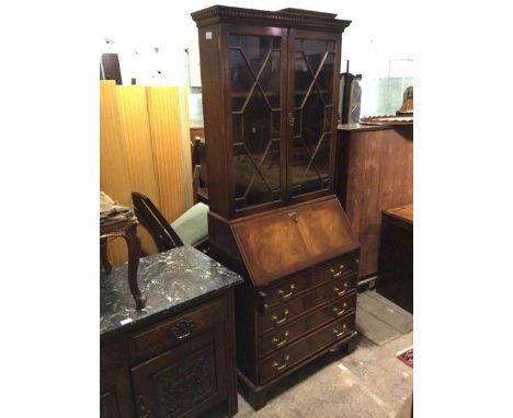 A Georgian style bureau bookcase, the cornice with dentil moulding above two glazed doors enclosing two adjustable shelves, w