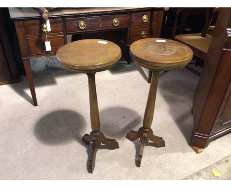 A pair of 1920s plant stands, the circular tops with reeded edges on turned stems and tripod base (76cm x 32cm)