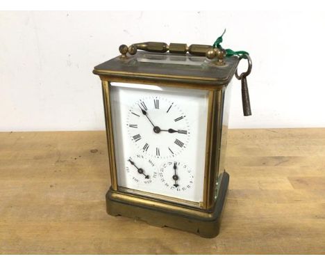 A brass and glass carriage clock with glass to top and four sides, the face with roman numerals to the hour, with subsidiarie