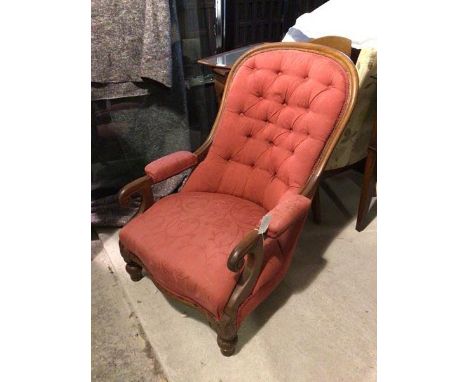A Victorian library chair with arched back above an upholstered and button back, with padded arms terminating in scrolls, on 