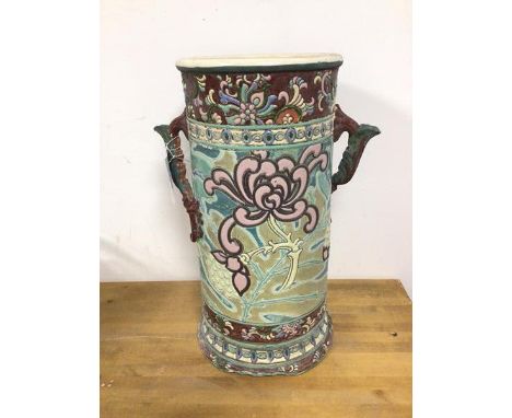 An early 20thc ceramic umbrella stand with handles to side and foliate decoration (40cm)