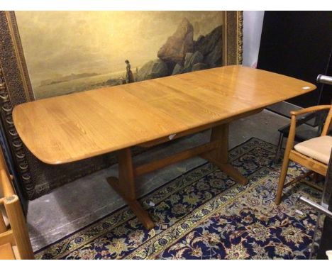 An Ercol extending dining table with magic leaf, the top with moulded edge on trestle support (open: 74cm x 230cm x 91cm)