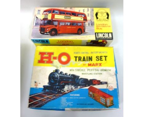 A MARX SMOKE PUFFING TRAIN SET together with a LINCOLN INTERNATIONAL ROUTE-MASTER SELF STEER BUS 
