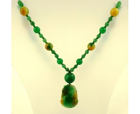 A HONEY JADE CARVED PENDANT, mounted on a jade bead necklace of alternate large and small beads, 75cm long, 96g 