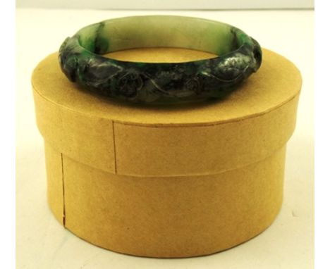 A LATE 19TH CENTURY JADE BANGLE carved with scrolls and symbols, 75mm diameter, 48g 