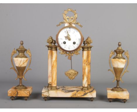 A French-style antique marble clock garniture with gilt metal mounts, the central clock featuring a portico design topped by 