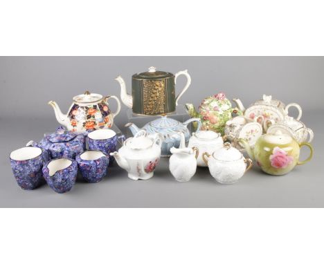 A collection of ceramic teapots and three part tea sets. Includes Sadler, The Village Teapot Collectables, Ringtons Chintz, G