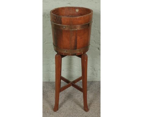 An Edwardian barrel planter by R.A. Lister &amp; Co, featuring a coopered oak bucket with brass bands, supported by a removab