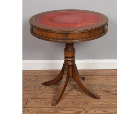 A round mahogany occasional drum table with red leather inset top and two drawers