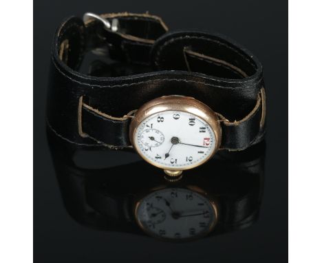 A 9ct rose gold trench wrist watch featuring Arabic numeral markers and subsidiary seconds dial. On removable leather strap a