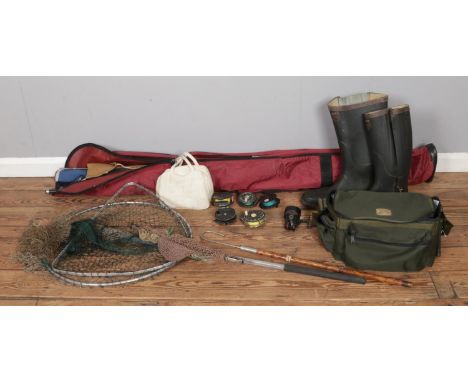 A collection of seven fly rods stored in a fishing holdall, accompanied by vintage landing nets, fishing waistcoat &amp; boot