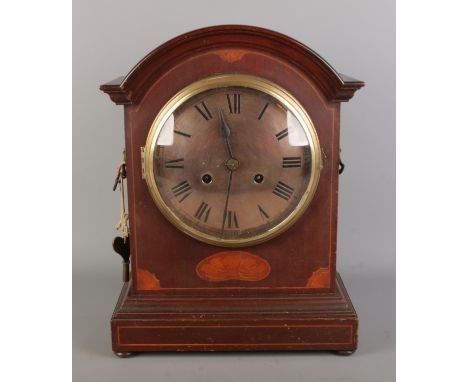 An antique German Regency style mantel clock, in mahogany inlaid case with brass dial and Roman numerals, movement plate stam