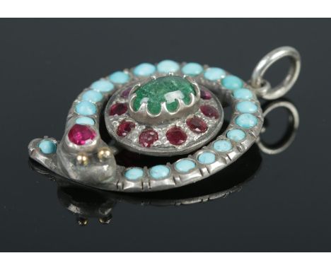 A white metal snake pendant set with turquoise stones, a central single emerald and ruby surround. Length: 3.2cm, Width: 2.6c