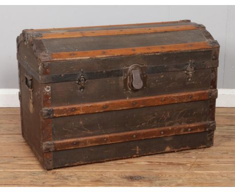 A dome top wooden bound steamer trunk, with 'Eagle Lock Co. lock' and twin handles.  Missing interior shelf.