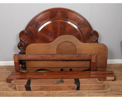 A Victorian flame mahogany double bed featuring carved foot and headboard.