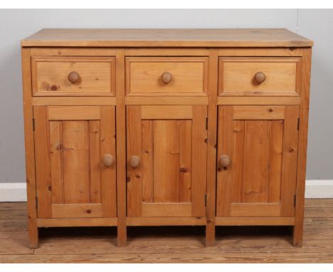 A pine sideboard featuring three drawers over cupboard doors. Approx. dimensions 118cm x 61cm x 90cm.
