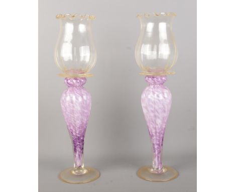A pair of blown glass trumpet vases on stands, each with a fluted and scalloped rim, clear trumpet-shaped body and a purple g