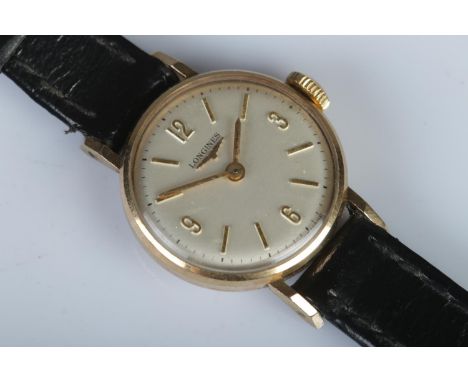 A ladies 9ct gold Longines manual wind wristwatch, on black leather strap. The silvered dial featuring quarterly Arabic numer