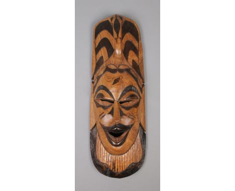 A large hand carved African tribal wall mask, with ebonised detail and loop handle to the top. Length: 50cm.