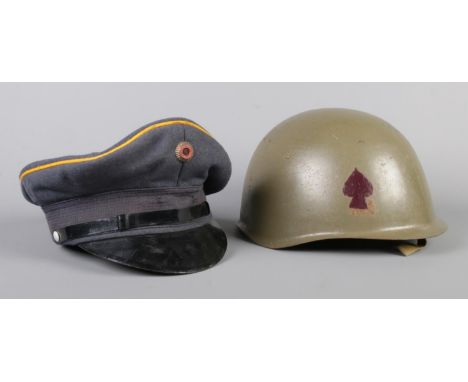 A WWII military steel helmet with liner and painted with a spade symbol, together with a 1975 German military cap by Bamberge