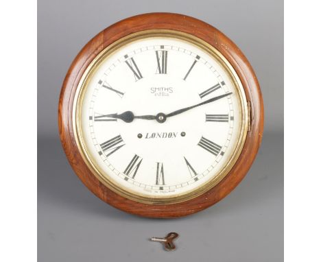 A mid-20th century Smiths of Enfield London railway chiming wall clock, with Roman numerals, diameter 39cm.  Pendulum and key