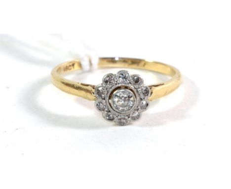 A diamond flower head cluster ring, stamped '18ct' and 'PLAT', finger size N .  Gross weight - 2.28 grams